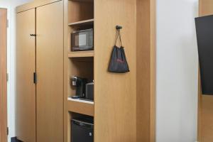 ダーラムにあるFairfield by Marriott Inn & Suites Durhamの電子レンジと黒いバッグが入った戸棚