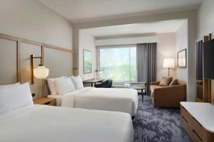 ダーラムにあるFairfield by Marriott Inn & Suites Durhamのベッド2台とソファがあるホテルの部屋 +9枚の写真