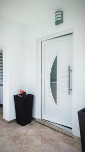 a white door with a round window on a wall at House Solis in Banjol