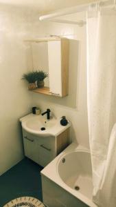 ein Badezimmer mit Waschbecken, Badewanne und Spiegel in der Unterkunft House Solis in Banjol + 21 Fotos