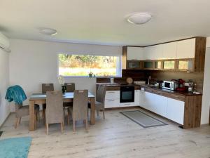 a kitchen and dining room with a table and chairs at Arany Sarok Vendégház in Kisgyőr