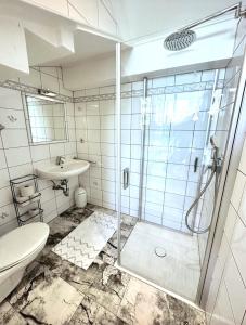 a bathroom with a shower and a toilet and a sink at Komfortappartement mit Terraasse in Wuppertal
