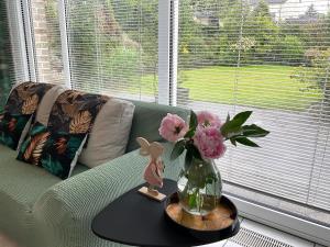 a vase with flowers on a table next to a couch at Komfortappartement mit Terraasse in Wuppertal