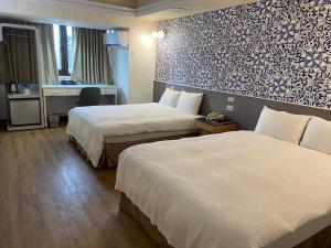 a hotel room with two beds and a desk at Ximen Relite Hotel in Taipei