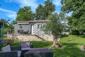 a house with a yard with chairs and a tree at House Nina in Pazin
