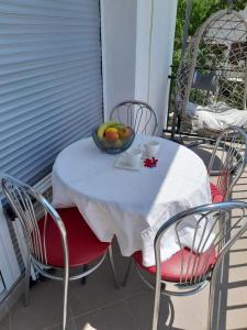 a table and chairs with a bowl of fruit on it at Apartments Roza in Dramalj +21 photos