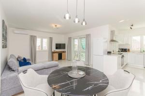 eine Küche und ein Wohnzimmer mit Tisch und Stühlen in der Unterkunft Apartments Quokka in Tribunj