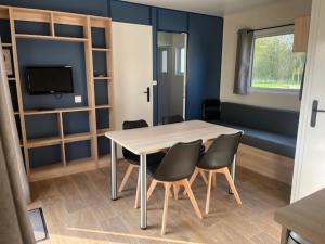 a room with a table and chairs and a tv at Camping VVF Pontivy in Pontivy