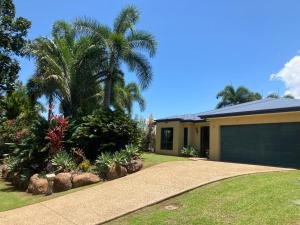 a house with palm trees and a driveway at Relaxed Tropical Living in Caravonica