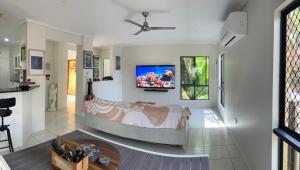 a living room with a bed and a tv on the wall at Relaxed Tropical Living in Caravonica