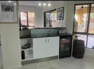 a kitchen with white cabinets and a counter top at Relaxed Tropical Living in Caravonica +25 photos