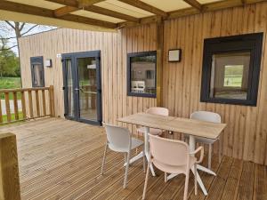 a wooden deck with a table and chairs on it at Camping VVF Le Kerostin in Pontivy