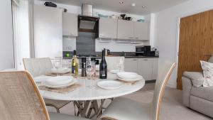 a white dining room table with chairs and wine glasses at Seahorses in Conwy