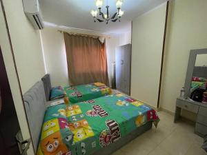 a bedroom with a bed with a hello kitty blanket on it at Elhlal luxury apartment in Hurghada +2 photos