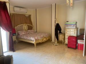 a bedroom with a bed and a dresser and a window at Elhlal luxury apartment in Hurghada