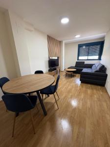 Una sala de estar con una mesa y sillas y un sofá. en Seira Apartment, en Burriana