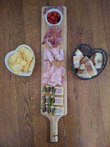 a wooden cutting board with different types of food on it at Le Domaine des Buis in Albon