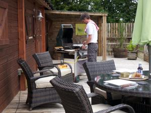 a man standing in front of a computer on a patio at Monart Farm Lodge in Milehouse