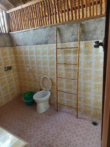 a bathroom with a toilet and a shower stall at Lumbung House in Gili Gede