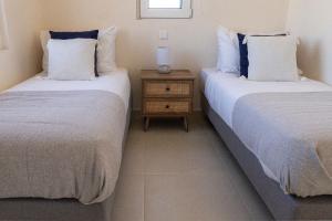 Dos camas una al lado de la otra en una habitación. en Phaedrus Living Seaside Thalassa Cretan 203, en Módhion 4 fotos más