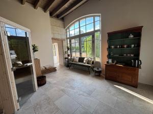a living room with a couch and a large window at Demeure de Beaulieu in Le Coudray-Macouard