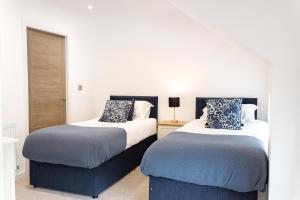 two beds sitting next to each other in a room at Stylish & Contemporary 2-Bed Townhouse - Parking - Wi-Fi - Netflix in Worksop