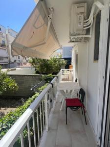 a balcony with a table and a bench on it at Cozy Apartment in central Kiato in Kiaton