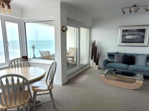 a living room with a blue couch and a table at Tides - Beach front apartment in Bracklesham Bay in Chichester