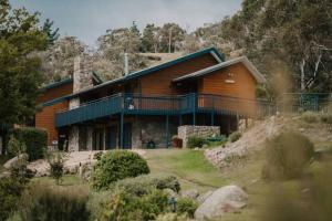 a large wooden house on top of a hill at Rooke River Lodge in Jindabyne