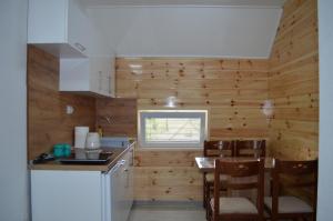 a kitchen with wooden walls and a table and chairs at Apartmani Srećko in Žabljak