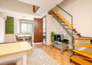 a living room with a staircase and a dining room at La casa di Luisa in Ronciglione