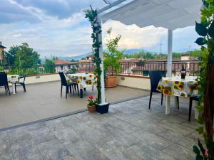 a patio with tables and chairs and an umbrella at Appartamenti la Piazzetta vicino a Firenze in Signa