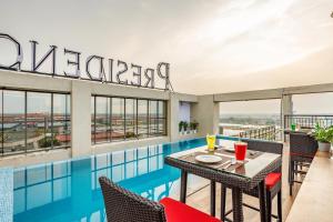 a balcony with a table and chairs next to a swimming pool at PRESIDENCY AIRPORT HOTEL in Cochin