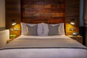 a bedroom with a large bed with a wooden headboard at North Lakes Hotel and Spa in Penrith