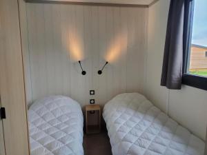 a bedroom with two beds and two lights on the wall at VVF Les Sableaux à Noirmoutier in Le Grand Vieil +30 photos