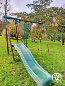 a playground with a slide in a park at La Maison de la pêche in Carelles +29 photos