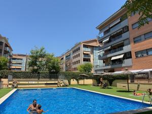 a group of people in a swimming pool in a building at Dúplex con encanto en Castelldefels in Castelldefels