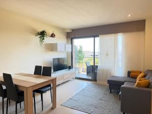 a living room with a dining room table and a television at Dúplex con encanto en Castelldefels in Castelldefels