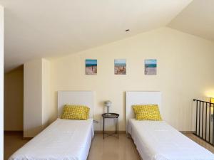 two beds sitting next to each other in a room at Dúplex con encanto en Castelldefels in Castelldefels +15 photos