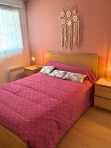 a bedroom with a large bed with a pink comforter at Vintage - Calme - Elégant - Terrasse in Saint-Paul-lès-Dax
