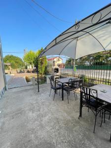 a group of tables and chairs under an umbrella at Vila Pajura in Costinesti