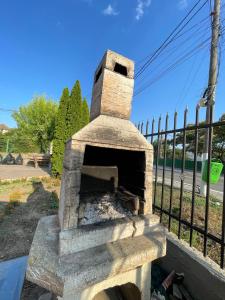 a stone pizza oven sitting next to a fence at Vila Pajura in Costinesti