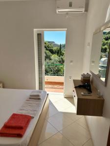 a bedroom with a bed and a bathroom with a window at Sunshine Guesthouse Dhermi in Dhërmi