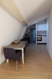 a dining room with a table and chairs and a kitchen at Viva la Vida in Bergen