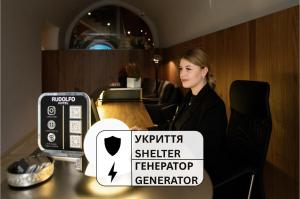 a woman sitting at a table with a sign on it at Rudolfo Hotel in Lviv
