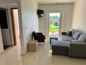 a living room with a couch and a chair at Sunshine Guesthouse Dhermi in Dhërmi