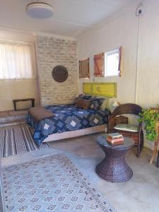 a bedroom with a bed and a table in it at The Candle Cottage at Keurkloof Valley Family Farm in Uniondale