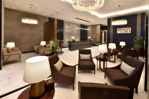 a lobby of a hotel with chairs and tables at Bahrain Airport Hotel Airside Hotel for Transiting and Departing Passengers only in Muharraq