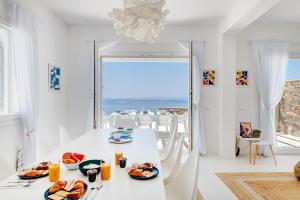 a white dining room with a table with food on it at Villa Lilak in Finikas