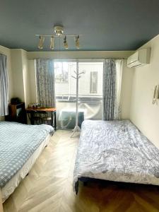 Giường trong phòng chung tại Tokyo Shinjuku East Sunrise House